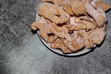 Polish sweet speciality called faworki in Polish language on plate, top view