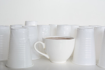 On a white background are white platonic cups. Among them is a ceramic cup. Concept - the fight...