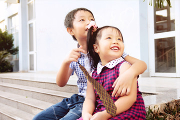 Brother and sister having fun and smiling outdoor together. Children happiness concept.