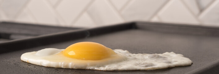 Detail of fresh egg cooking on gas grill with space for text ideal for breakfast menu