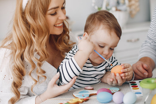 Mother and daughter paint eggs. Family in a kitchen. Preparing for Easter