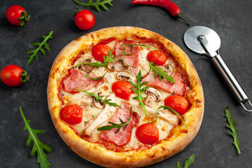  meat pizza with cheese, chicken, ham, champion mushrooms, tomatoes on a stone background
