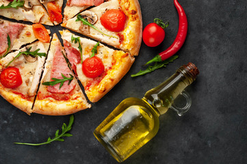  meat pizza with cheese, chicken, ham, mushrooms, tomatoes on a stone background