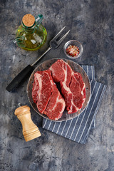 Raw beef steak on dark gray background
