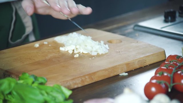 Chef chopping garlic on a cutting board in a restaurant. Prepare food on cuisine. Healthy nutrition in gourmet kitchen. Making meal. Prepare food to eat. Delicious dish. Cooking eating.