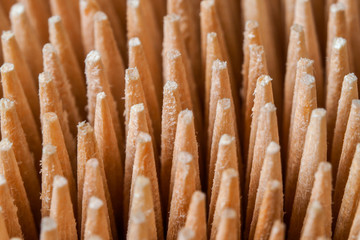 Close-up of a group of wooden toothpicks pointed and sharp, brown, forming a pattern or texture