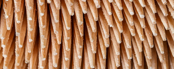Close-up of a group of wooden toothpicks pointed and sharp, brown, forming a pattern or texture