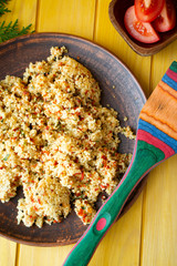 Couscous with shrimps and colorful vegetables in a bowl, flat lay vertical image