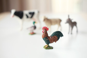 Group of realistic figures of farm animals standing on a shelf