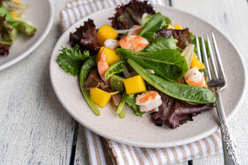 Healthy homemade fresh salad with green mix, avocado, shrimps, and mango. Restaurant style salad.