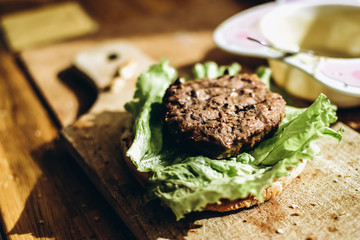Hamburger with lettuce and mayonnaise sauce and a juicy beef cutlet. Lifestyle