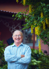 portrait of happy confident mature man on his own yard