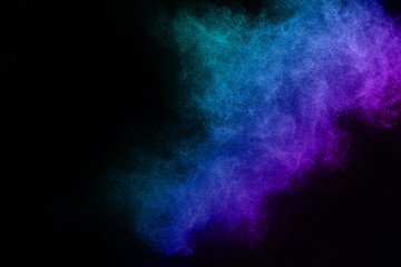 Freeze motion of blue and pink color powder exploding on black background.