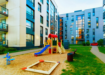 Modern residential apartment flat house building and children playground reflex