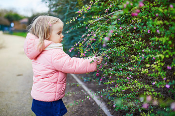 Adorable little toddler girl in Parisian park on a spring or fall day