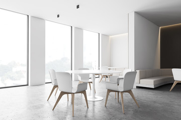 White and gray cafe corner with round tables