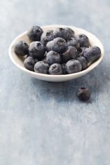 Bilberries on bright wooden background. Concept for healthy nutrition. Copy space.