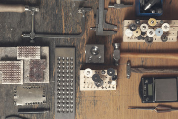 Top view of different goldsmiths tools on the jewelry workplace. Desktop for craft jewelry making...