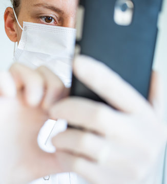 Female Doctor Wearing Mask Using Smart Phone