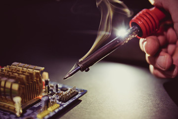 soldering iron smokes on a dark background close-up