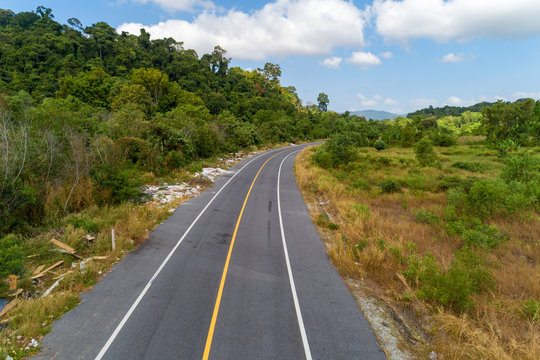 Asphalt road curve with yellow line on road image by drone camera high angle view.