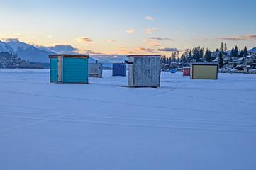 Fototapeta na wymiar Ice fishing shacks on Lake Windermere at the town of Invermere, British Columbia, Canada