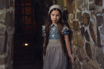 Frightened girl in the dungeons of an ancient castle.  Stylization. Vintage toning.