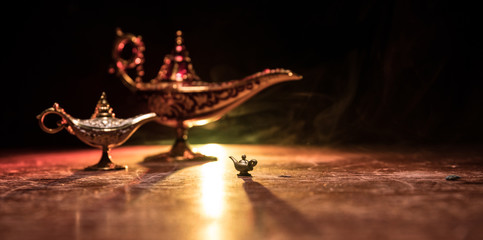 Lamp of wishes concept. Antique Aladdin arabian nights genie style oil lamp with soft light white...
