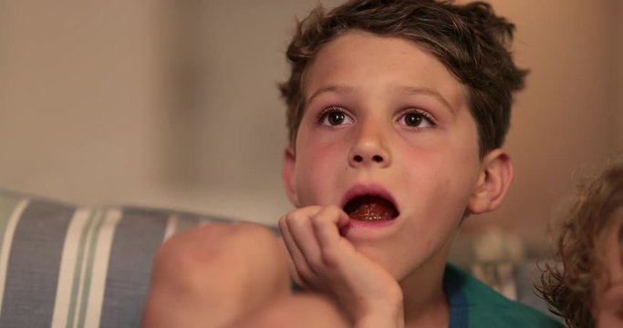 Child boy engrossed by TV content. Kid watching TV absorbed