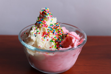 Vanilla and strawberry ice cream served in glasses, with sweet sprinkles and, Bogotá Colombia,...