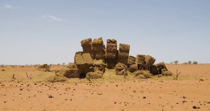 Pile of hay bales stacked upon one another in the middle of the Australia Outback