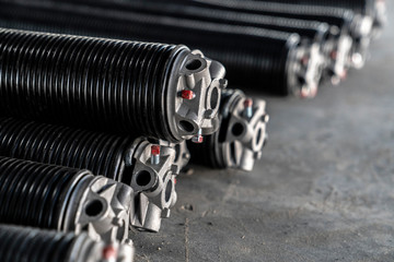 Commercial garage door springs stacked on a concrete floor