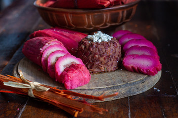 Tamal pisque traditional Nicaraguan food, along with fried beans and cheese on a rustic wooden...