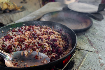 cooking traditional Nicaraguan food known as gallo pinto and tortillas on a wood fire