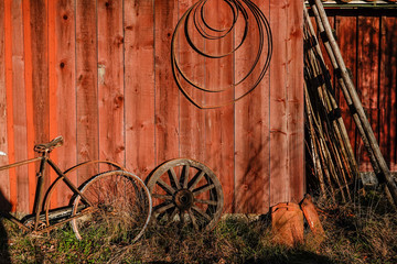 Stockholm, Sweden A picturesque red barn wall with old farm tools and a bicycle.