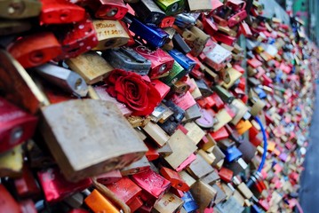 Many love locks hang on the Hohenzollernbrücke bridge in Cologne (Koln), Germany. Couples symbolize their love by locking a padlock on the bridge and throwing the key into the Rhine river.