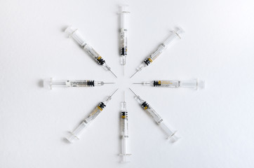 Circle of eight syringes on a white background