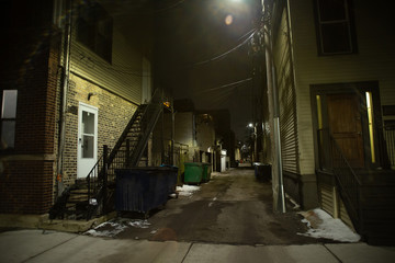 Naklejka na ściany i meble Dark and eerie urban city alley at night in the winter