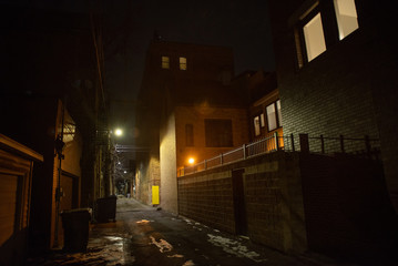 Dark and eerie urban city alley at night in the winter