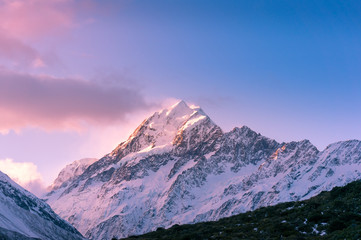 Fototapeta na wymiar Snow covered mountain peak at sunset. Winter mountains landscape