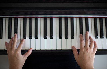 Manos sobre un piano tocando m&uacute;sica