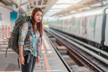 Asian woman traveler tourist waiting modern train  at train station, Selective focus, Travel concept.