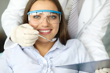 Girl in clinic smiles, individual oral hygiene. Regular checkup with dentist is guarantee health. Standard examination and professional oral hygiene. Prevention diseases, surgical treatment.