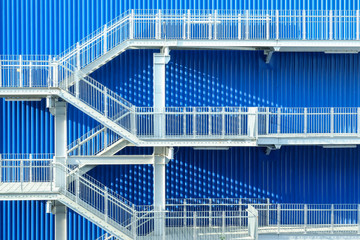 Metal stairs with blue wall in background