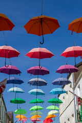 Fototapeta na wymiar Colorful umbrellas hanging above the street in Caernarfon, Wales