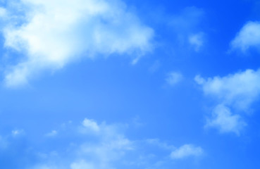 ิblue sky against white floating clouds background
