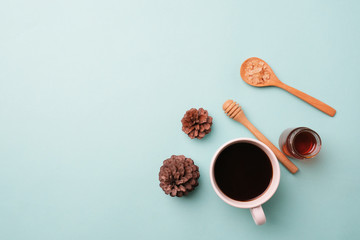 white cup coffee and sugar in spoon wood on light blue background