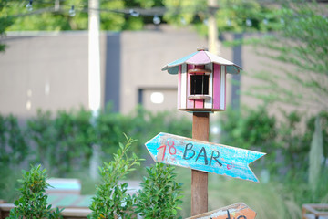 Birdhouse. A wooden bird house in colorful pink, blue and yellow, shallow depth of field.