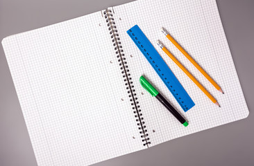 Pencils, pen and ruler are on an open notebook. Office. School supplies.