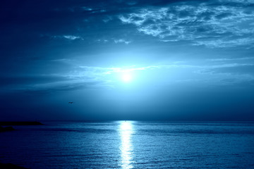Fototapeta na wymiar Sunrise over the sea near the coast of Sicily, Italy. Natural bakground blue color toned